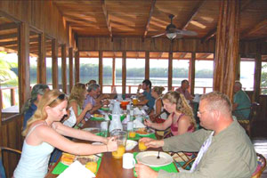 Guests enjoy a family-style meal with a broad and breezy river view.